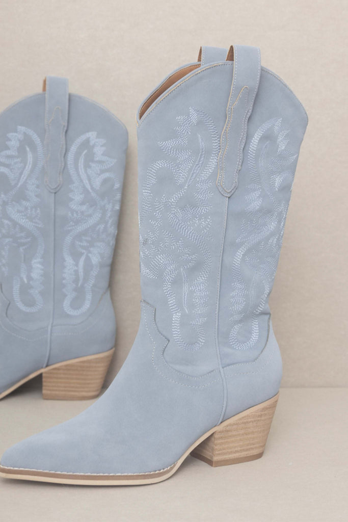 Slate blue boots featuring embroidery throughout. It has two straps on each side for an easy way to slip them on. They are full suede and have a unique soft look and feel. Perfect for a long lasting boot wear. 